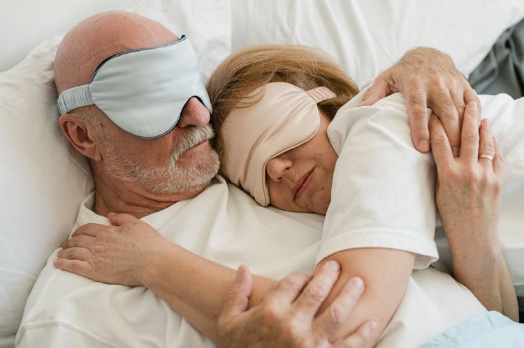 Couple asleep wearing eye masks